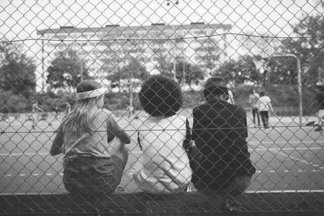a group of people sitting on a fence