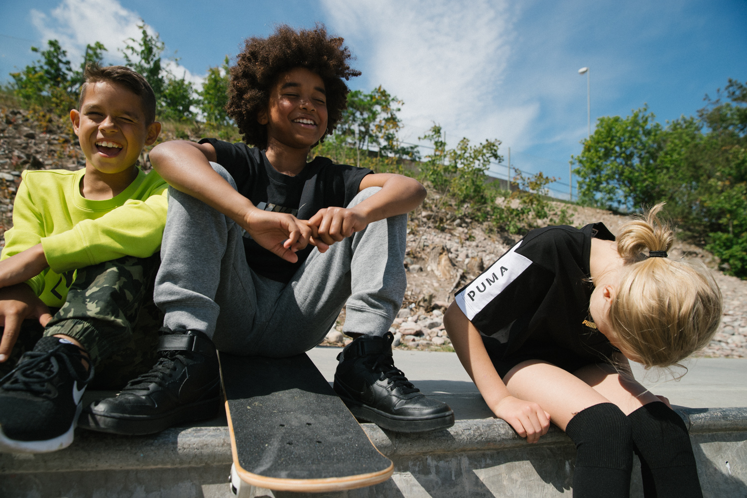 a group of kids sitting on a ledge