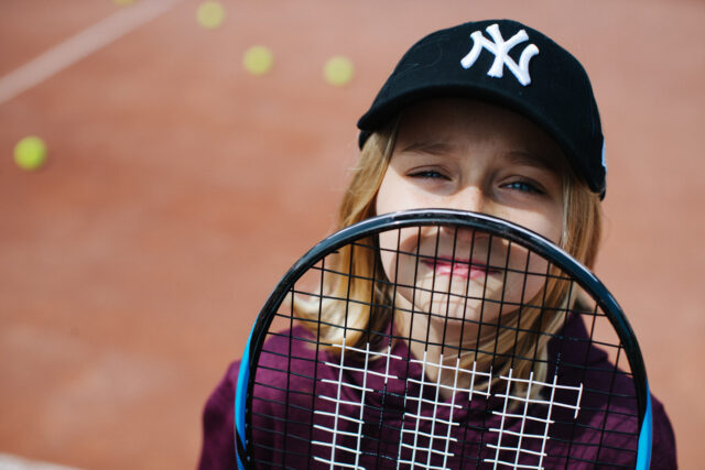 a girl holding a tennis racket