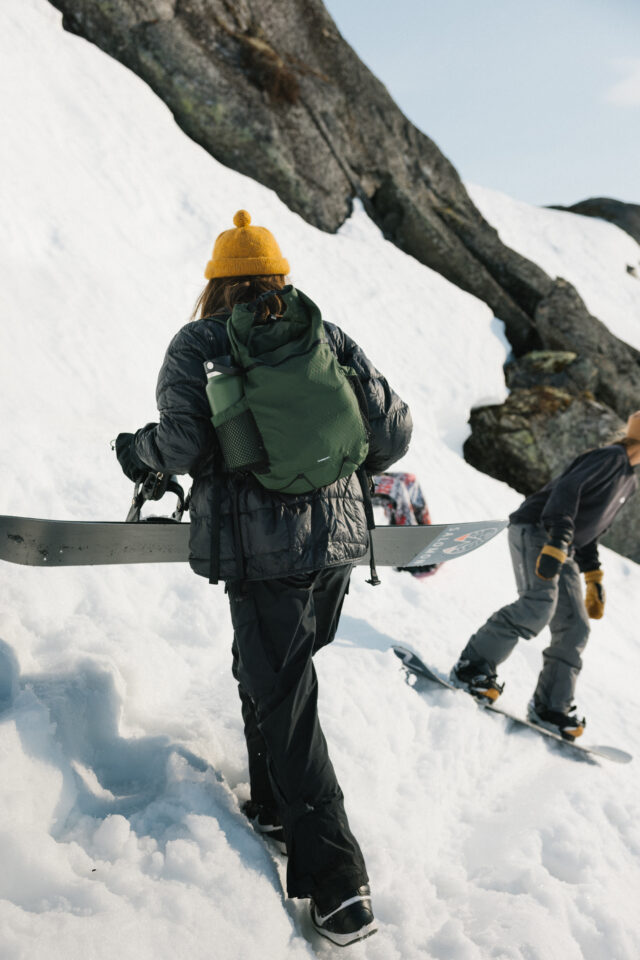 a person with a backpack and snowboard on a snowy mountain