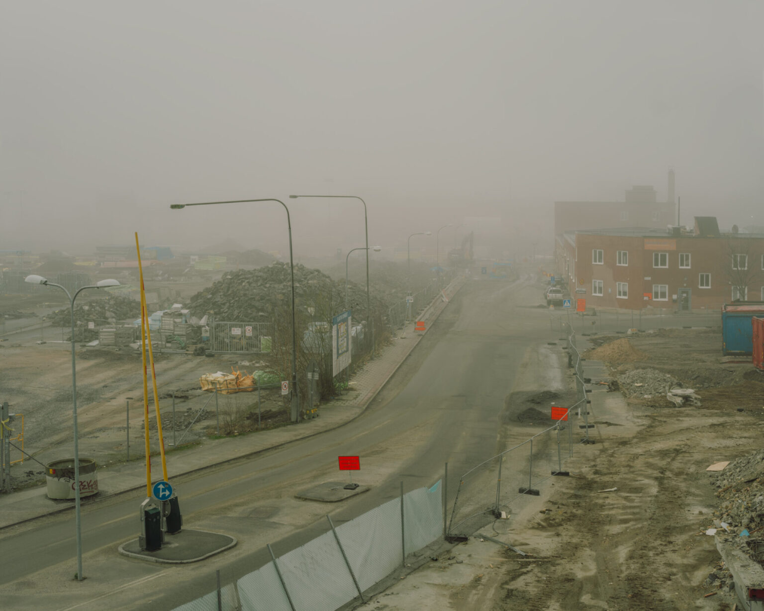 a road with a lot of debris and buildings in the background