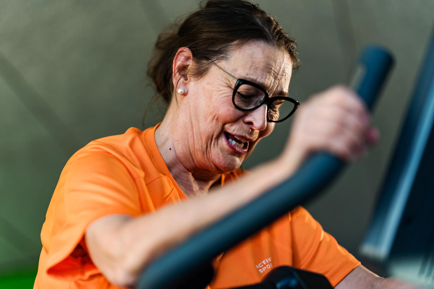 Äldre kvinna tränar på motionscykel