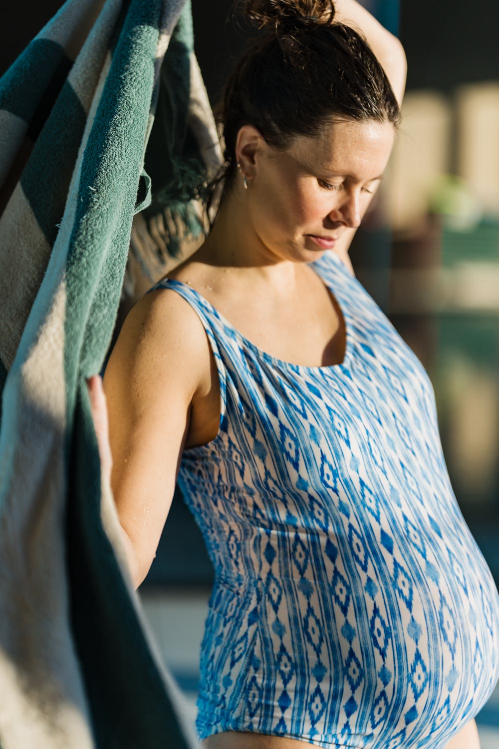 En gravid kvinna torkar sig med handduk.