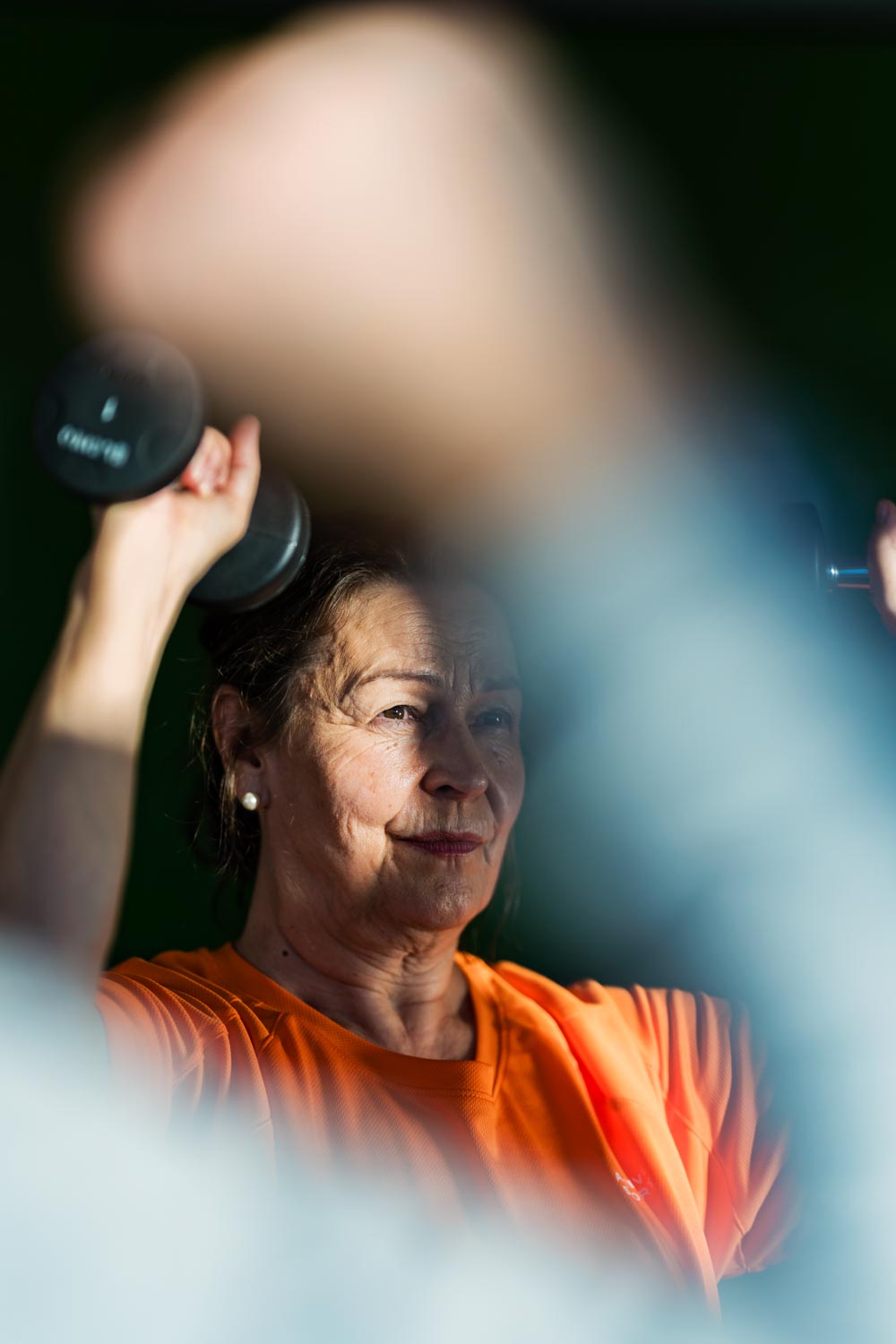 Äldre kvinna tränar med hantlar.