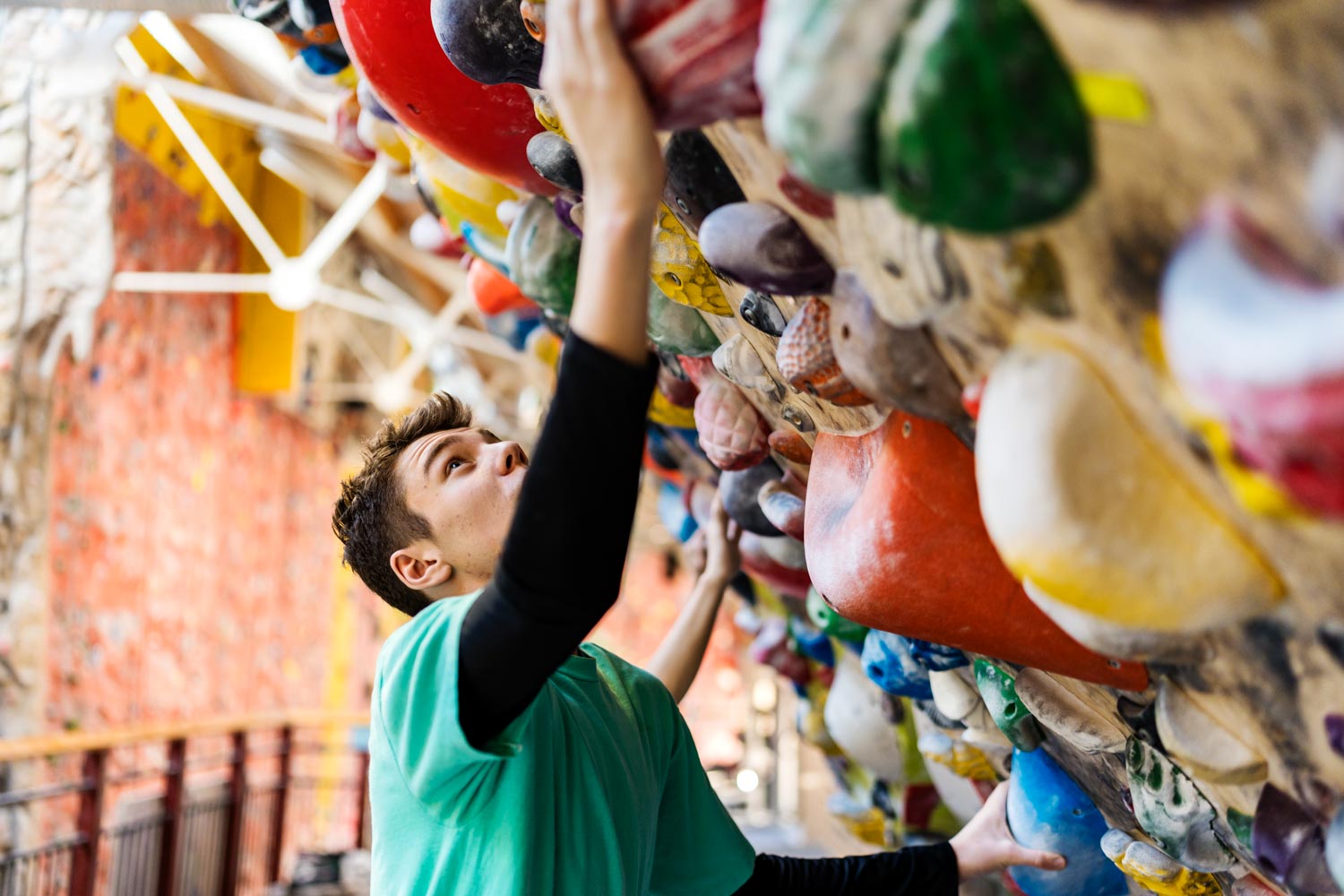 Ung kille klättrar på klättercenter.