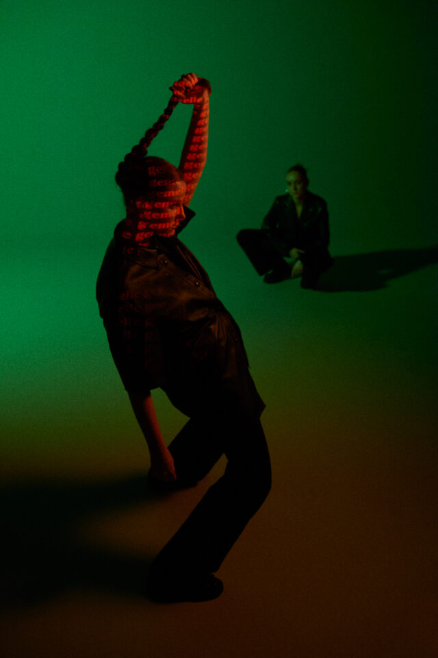 a woman with her arms raised and a person sitting on the ground