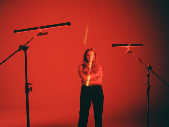 a woman standing in front of two microphones