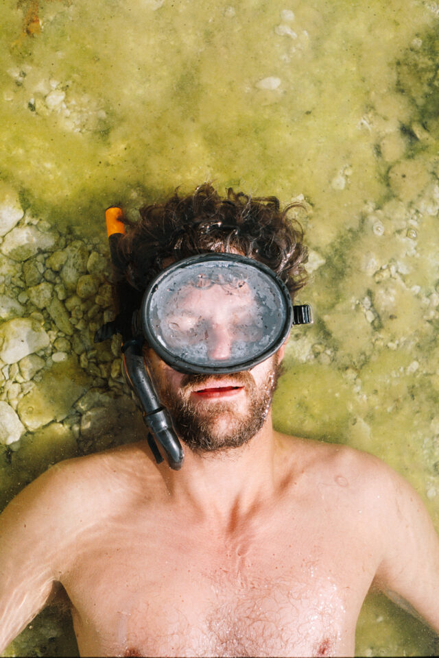 a man lying in water with a mask on his face