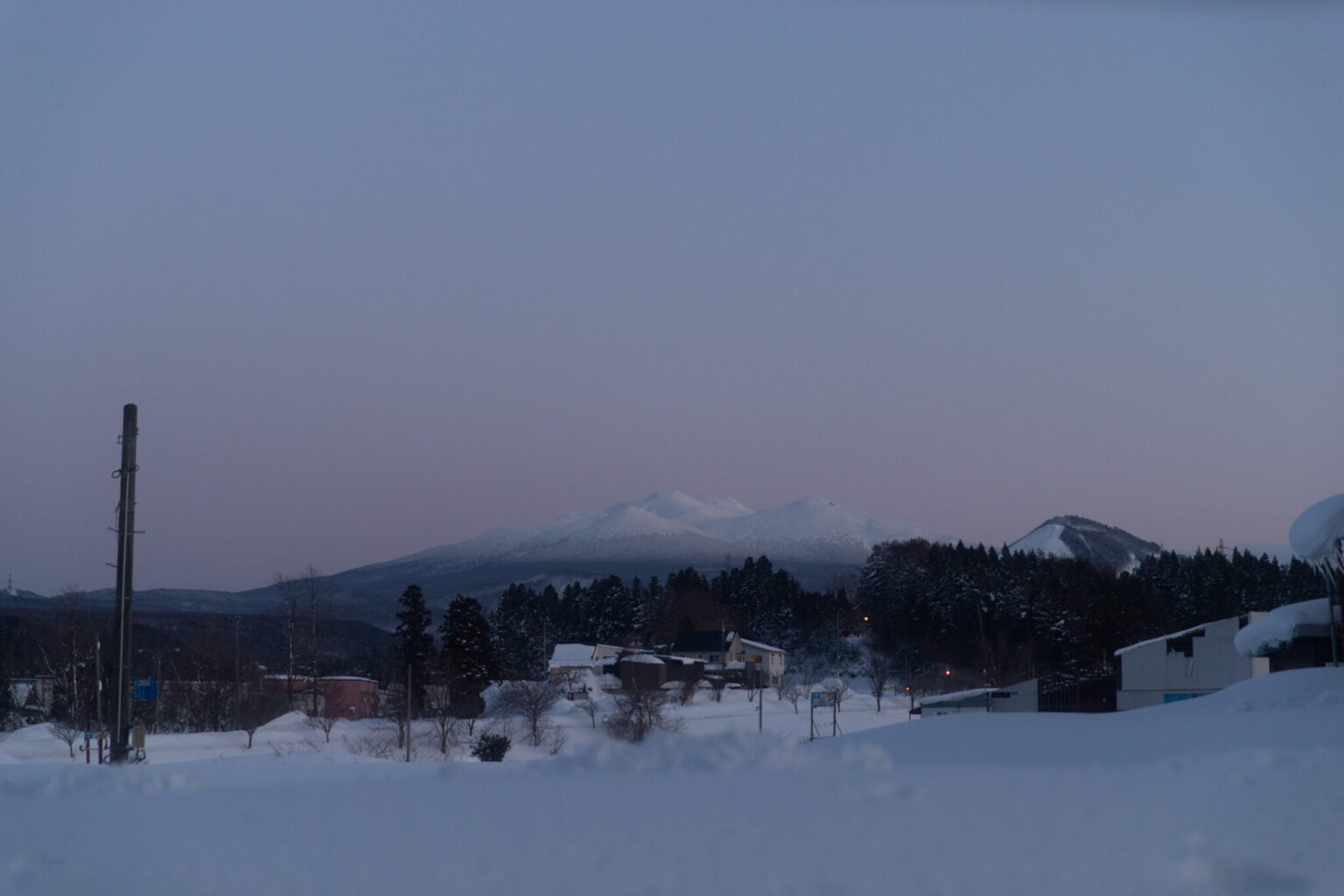 a snowy landscape with a mountain in the background