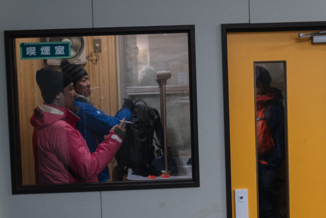 a group of people standing in a room with a window