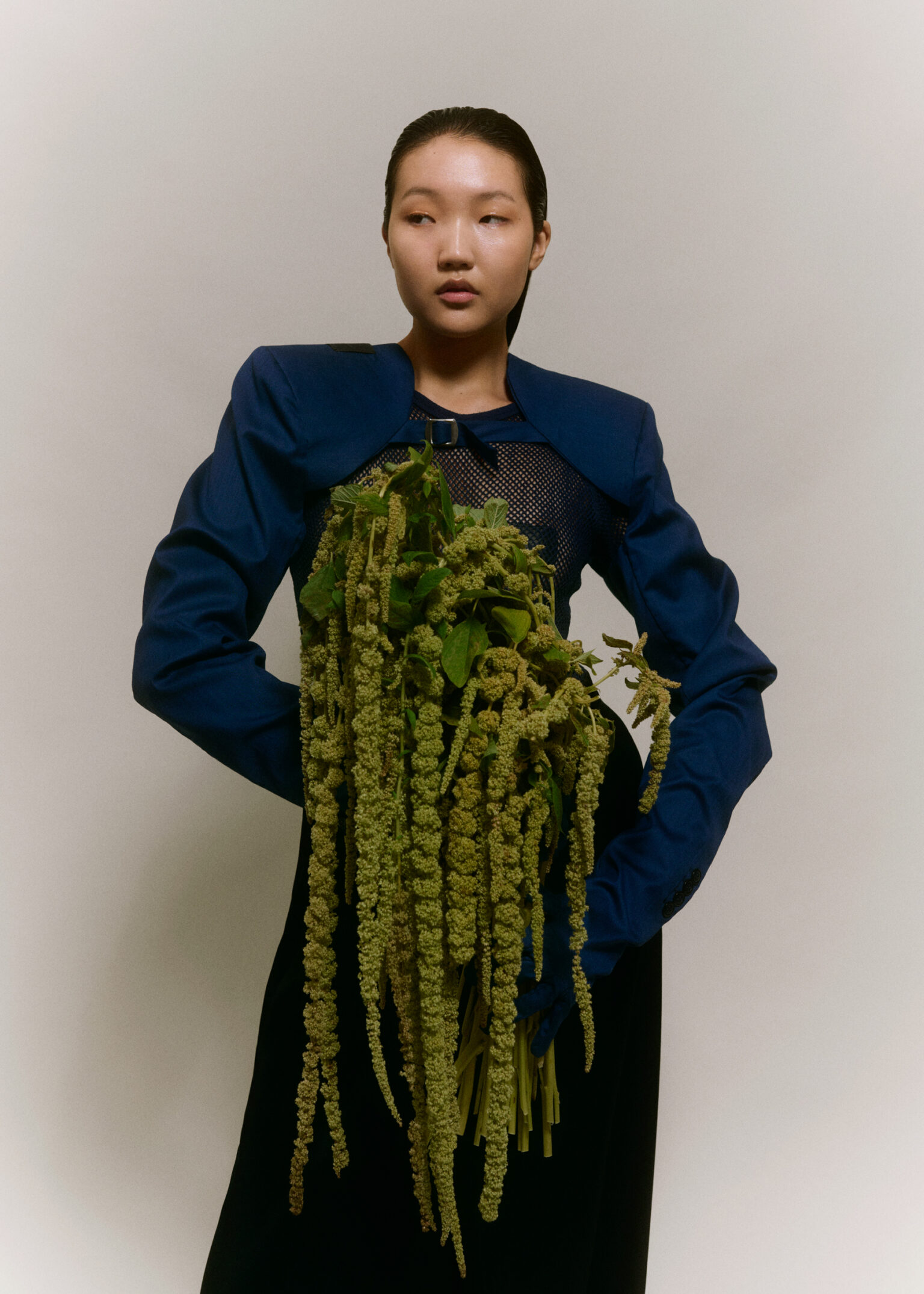 a woman holding a bunch of green plants