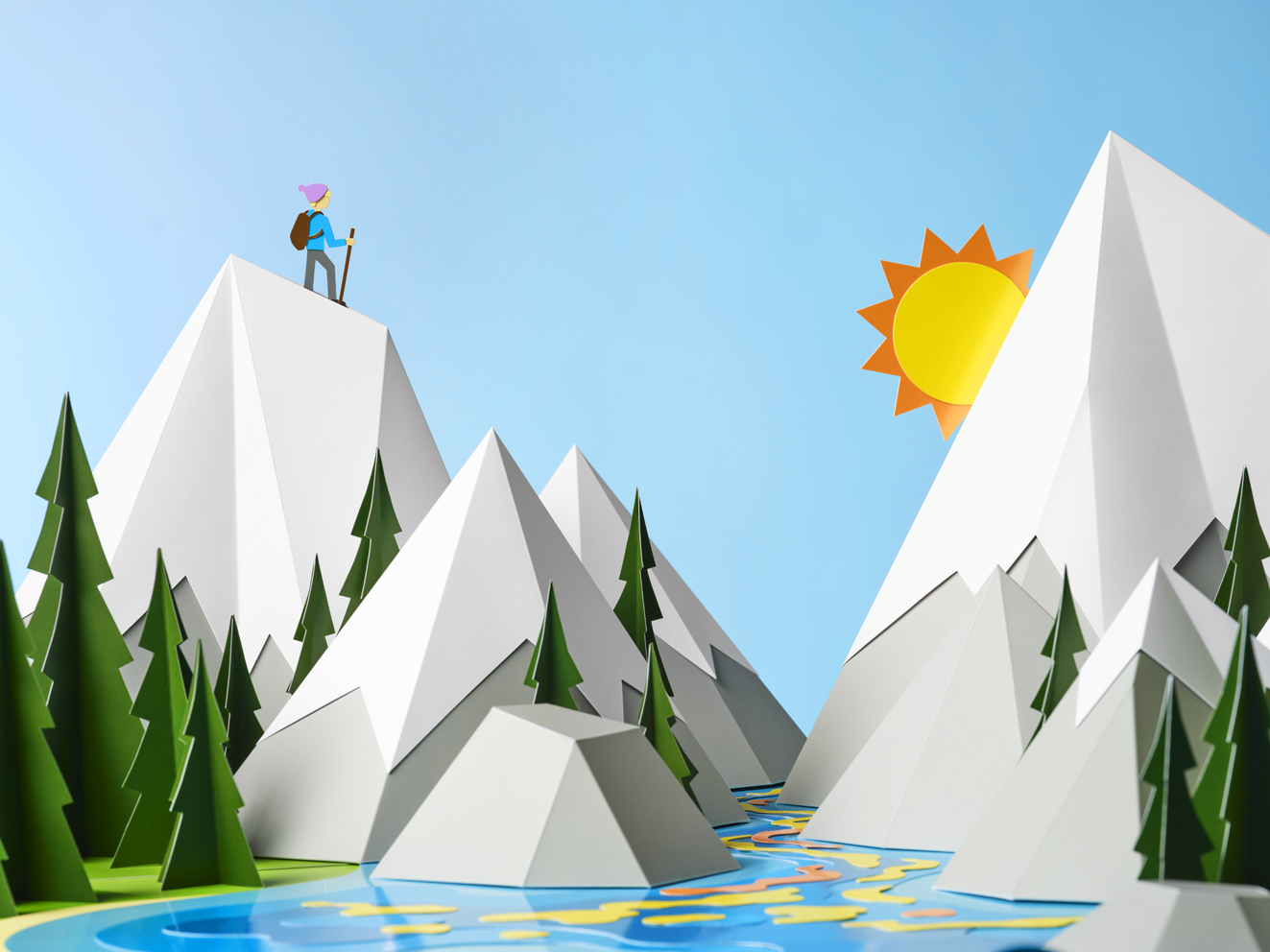 a paper cut out of a mountain with a person standing on top of a mountain
