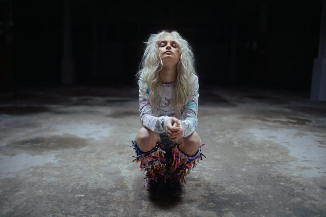 a woman with long hair squatting down