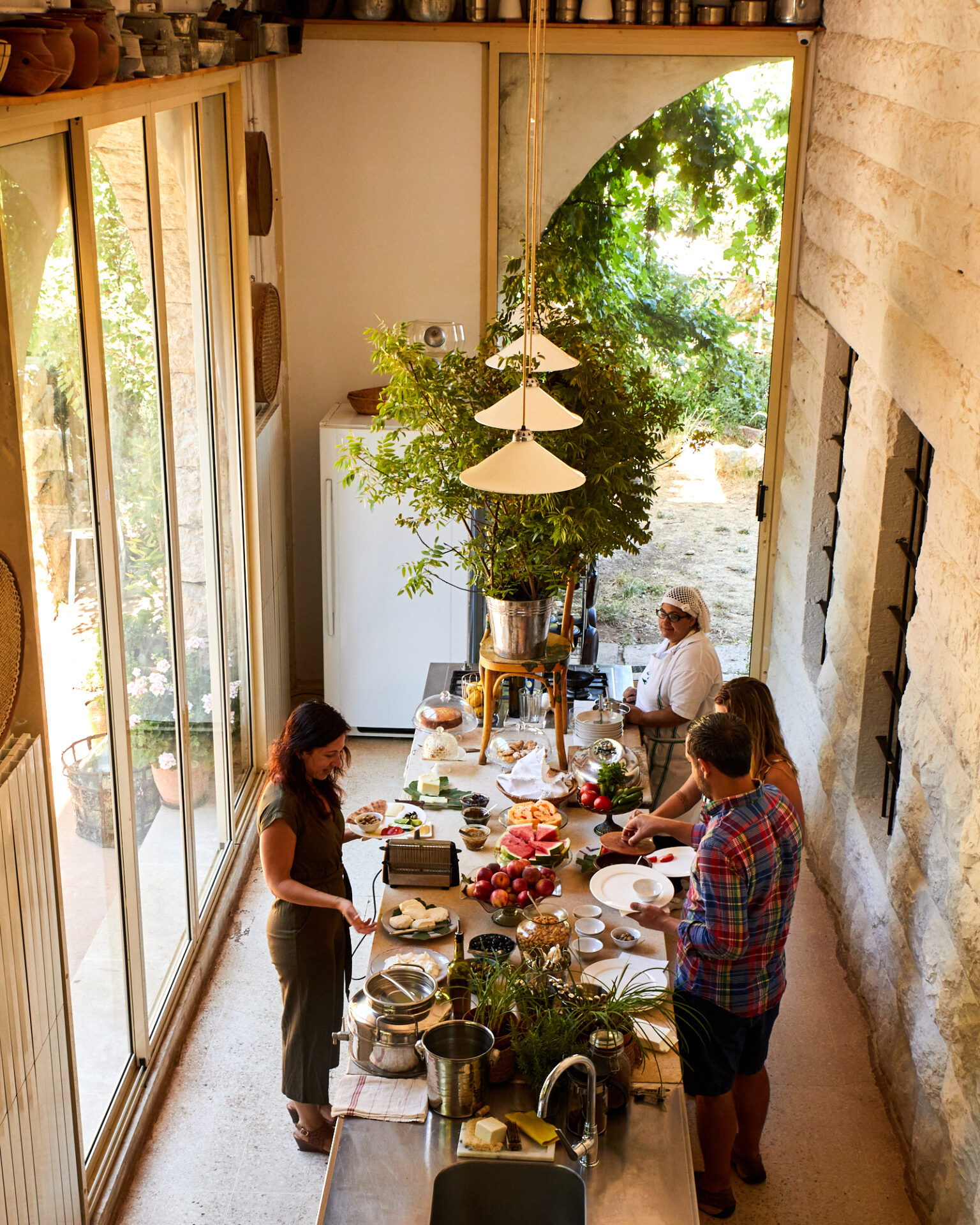 a group of people standing around a table with food on it