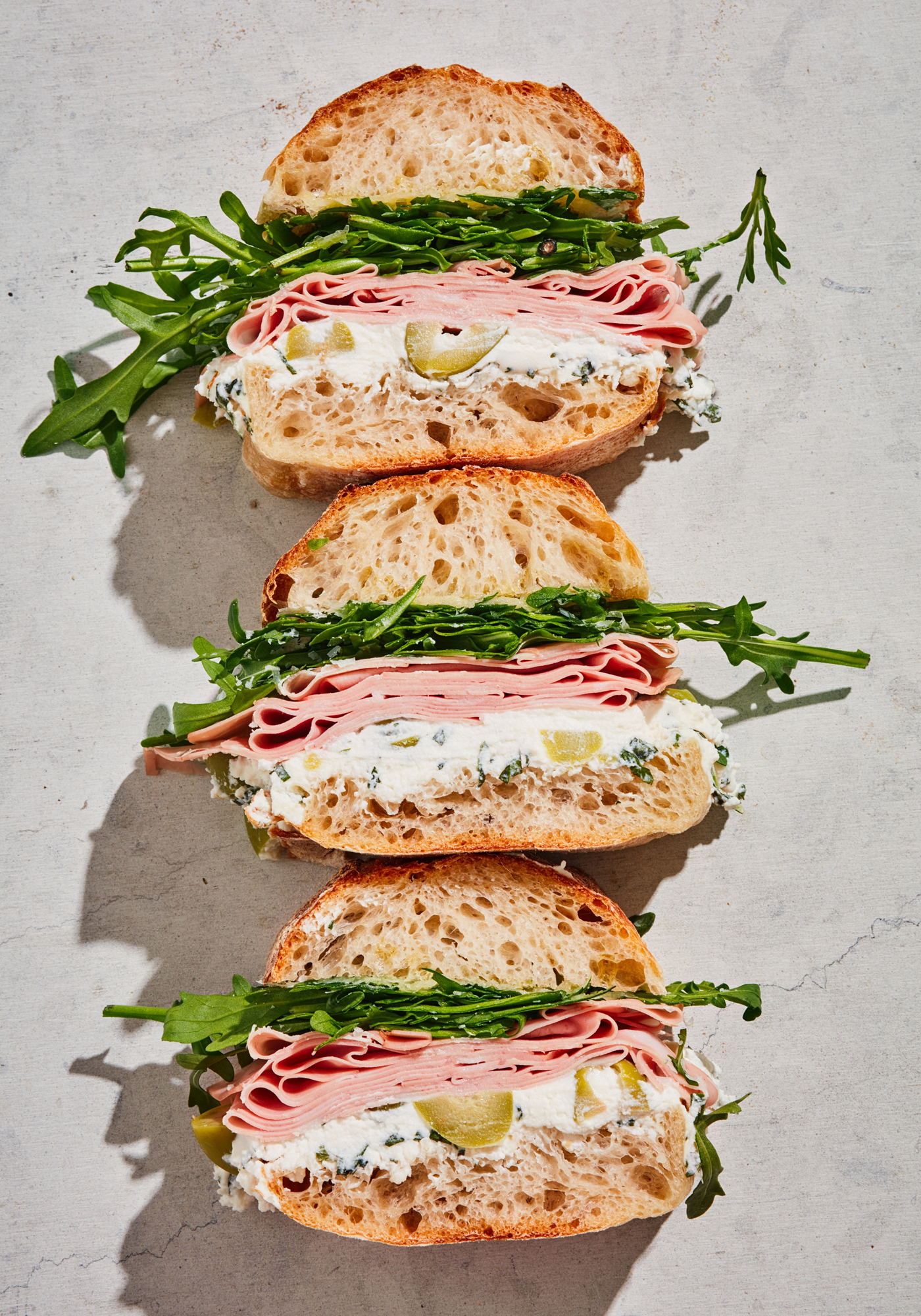a row of sandwiches with meat and vegetables