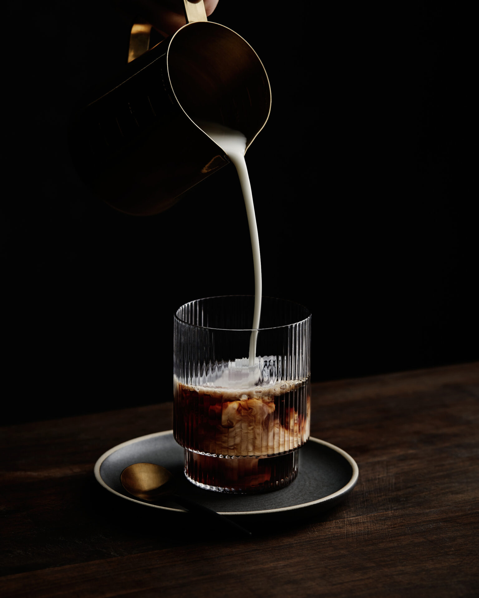 a pouring milk into a glass of liquid