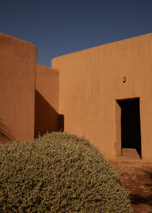 a building with a door and a bush