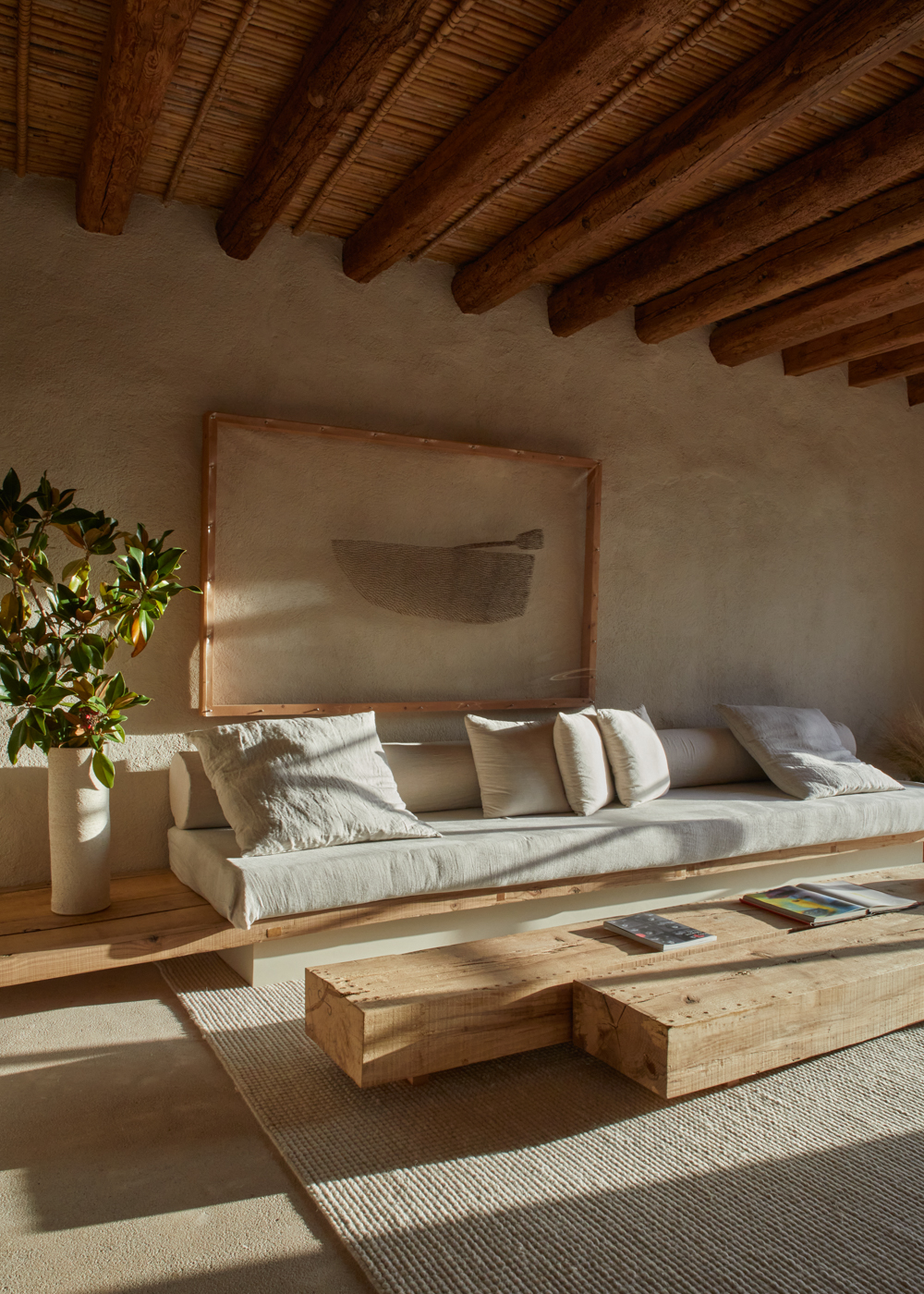 a couch with pillows and a table in a room with wood beams