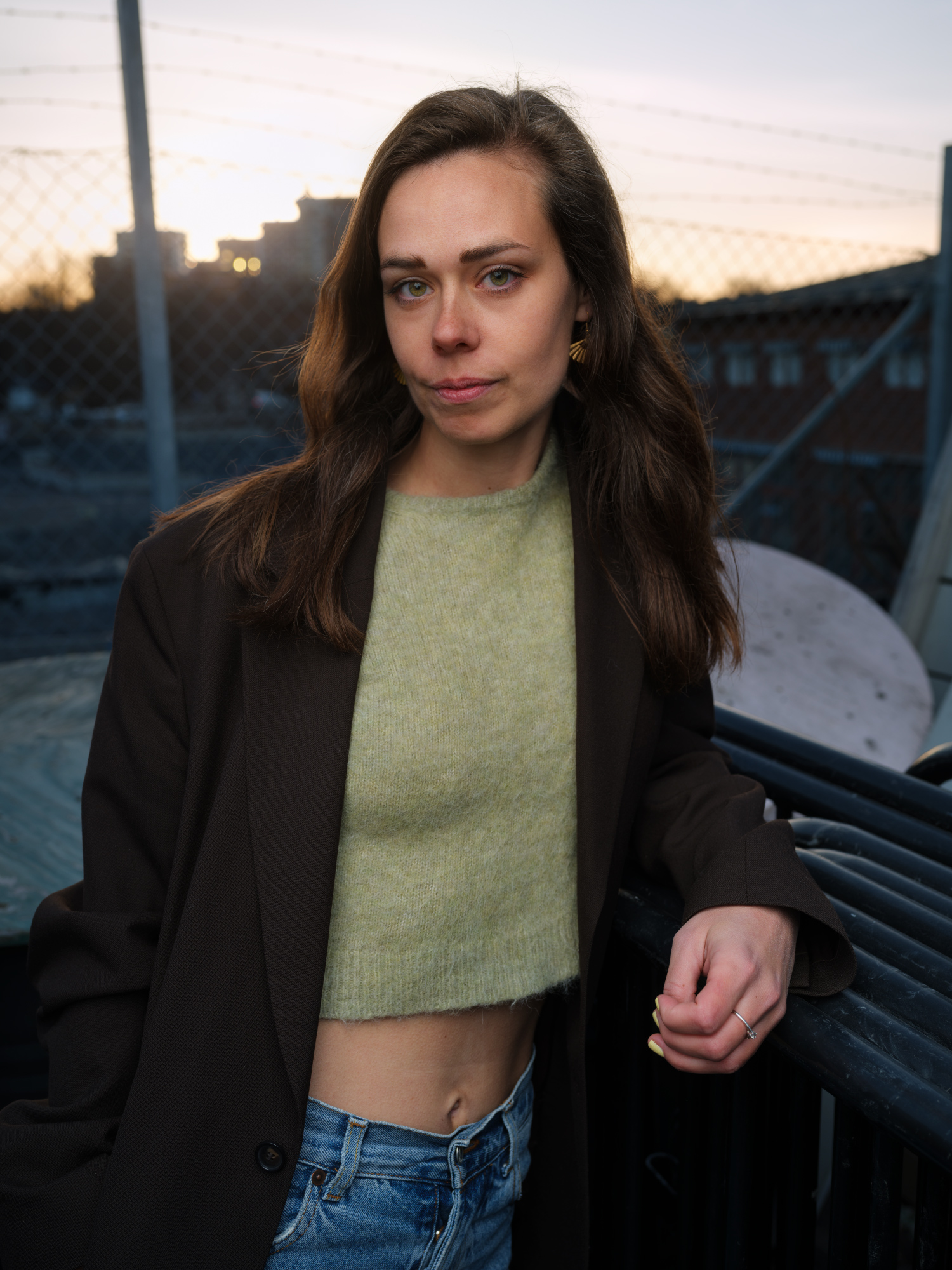 a woman standing next to a fence