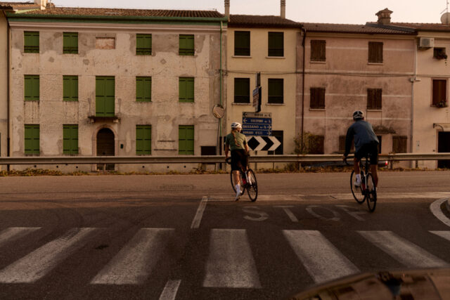 two people riding bicycles on a street