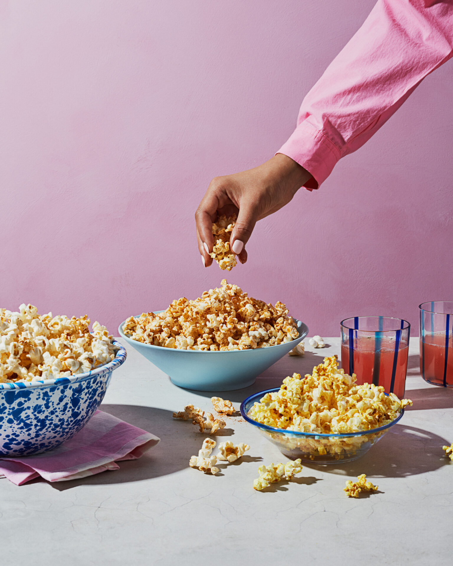 a hand holding popcorn in a bowl