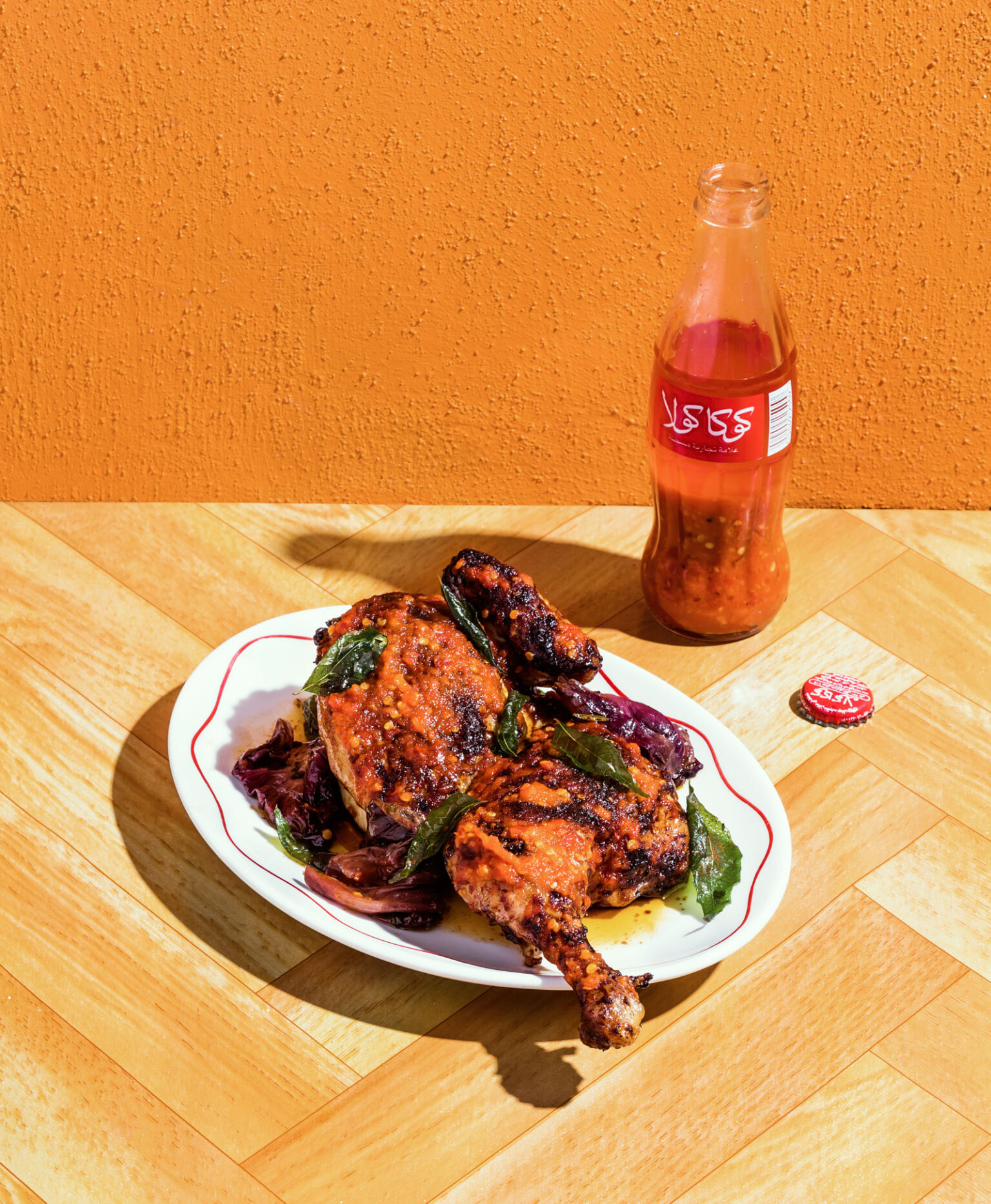 a plate of chicken and a bottle of soda