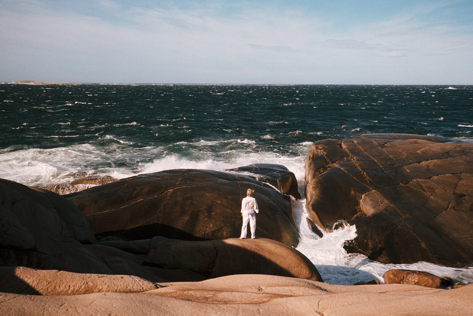 a man standing on a rock by the ocean