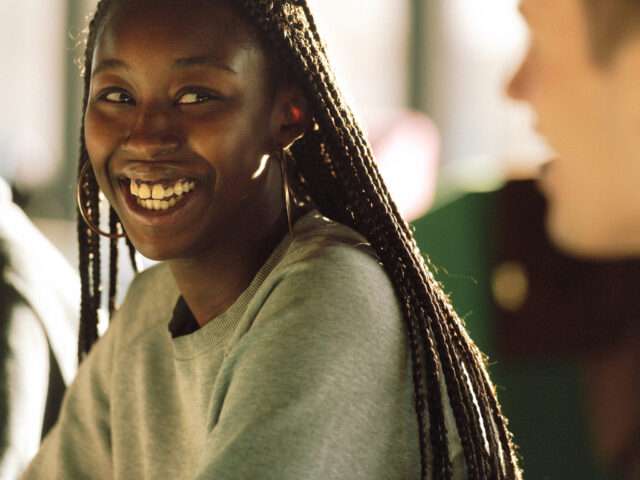 a woman smiling with long braids