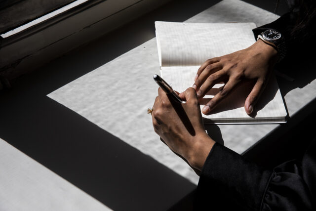 a person writing on a notebook