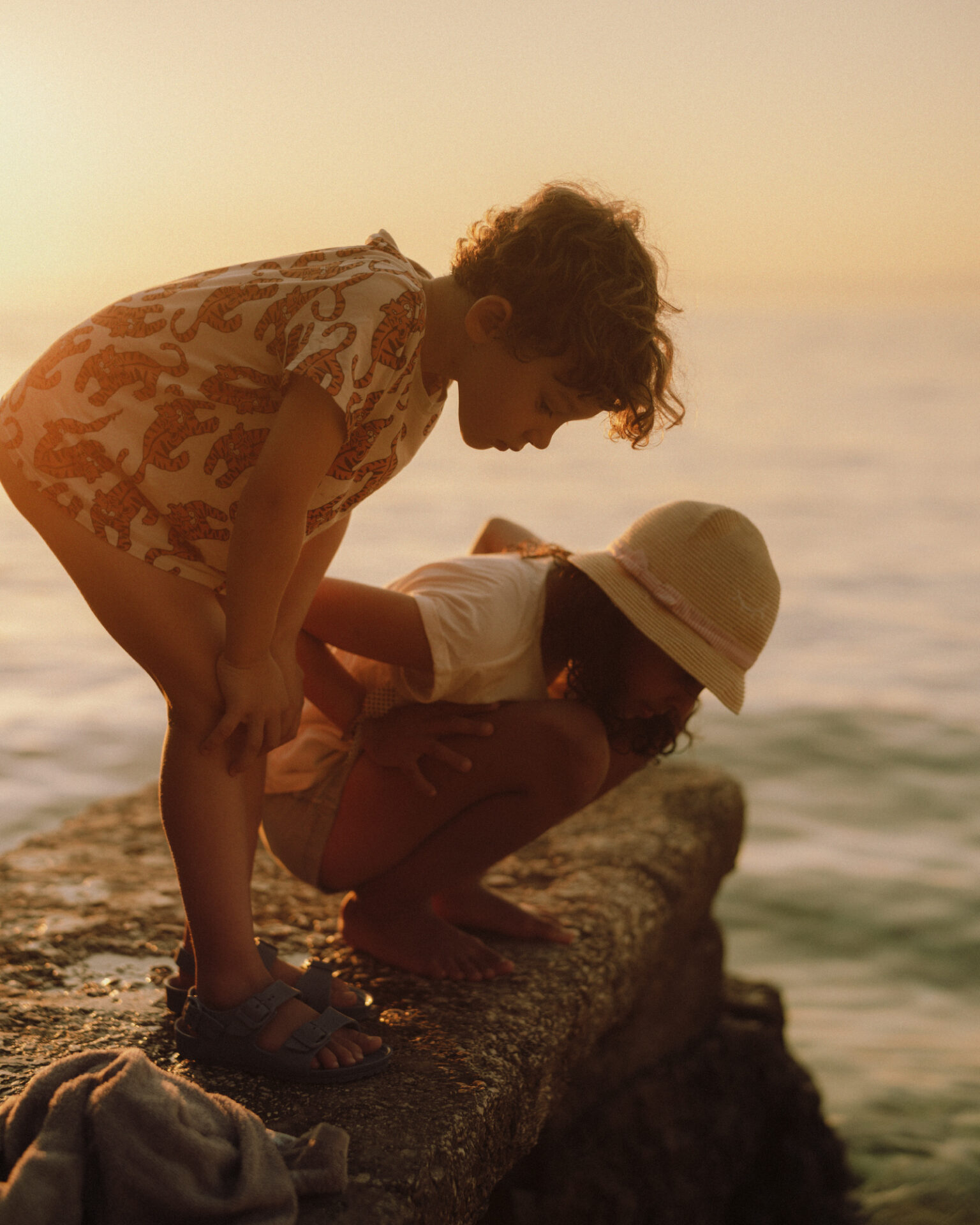 two children playing on a rock