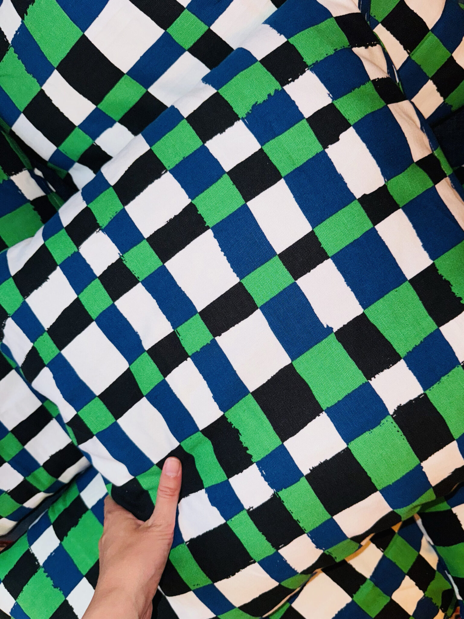 a hand touching a pillow