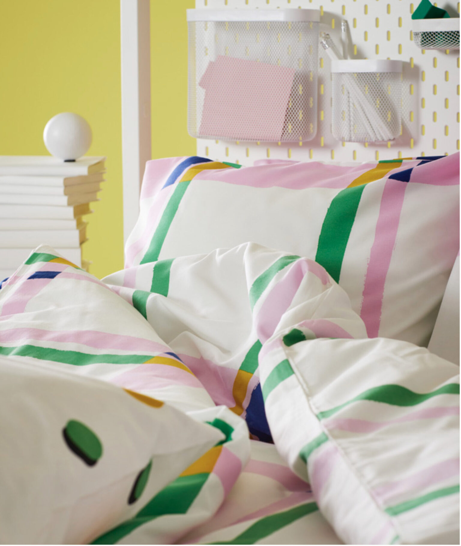 a bed with colorful pillows and a white headboard
