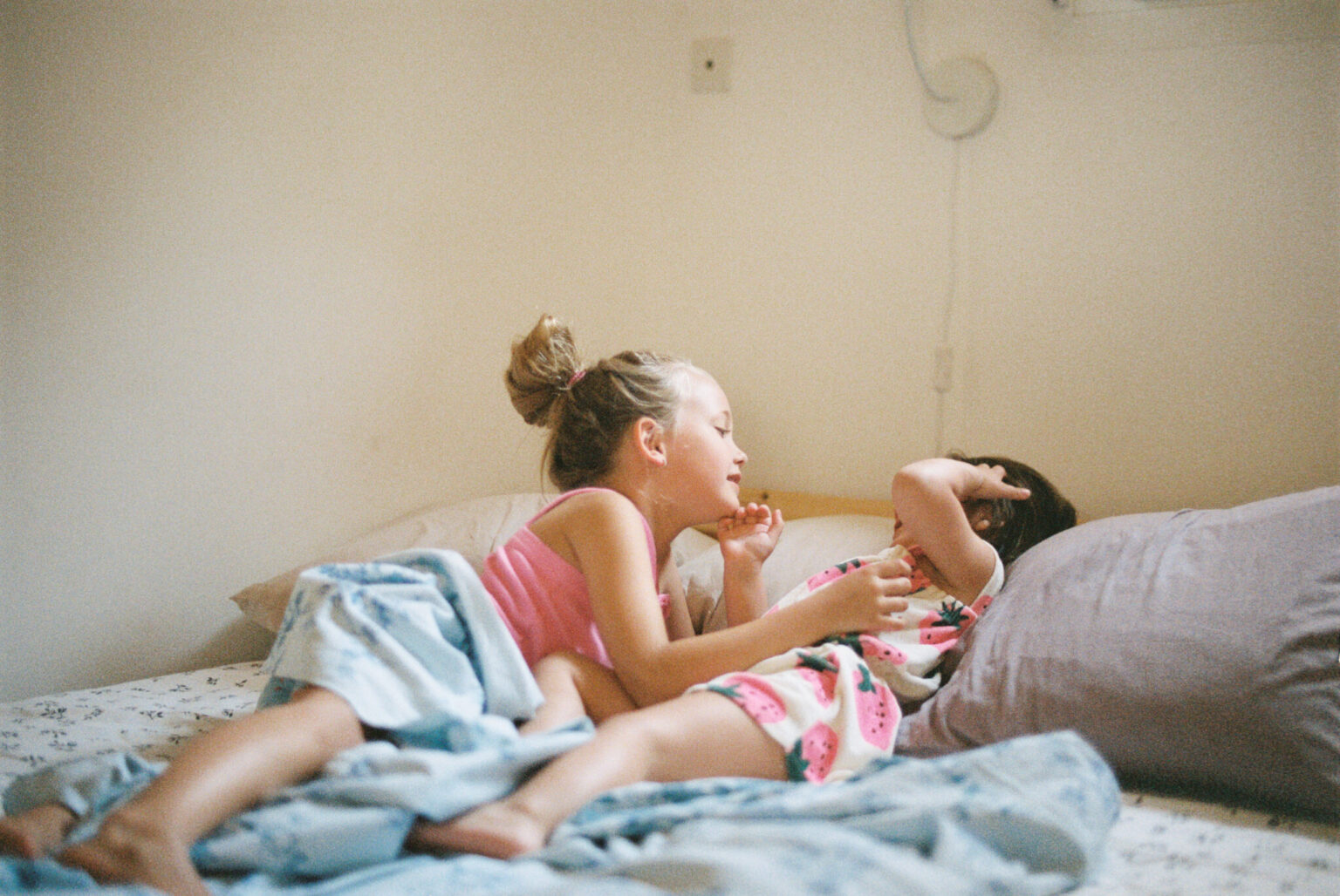 a girl lying on a bed with a baby