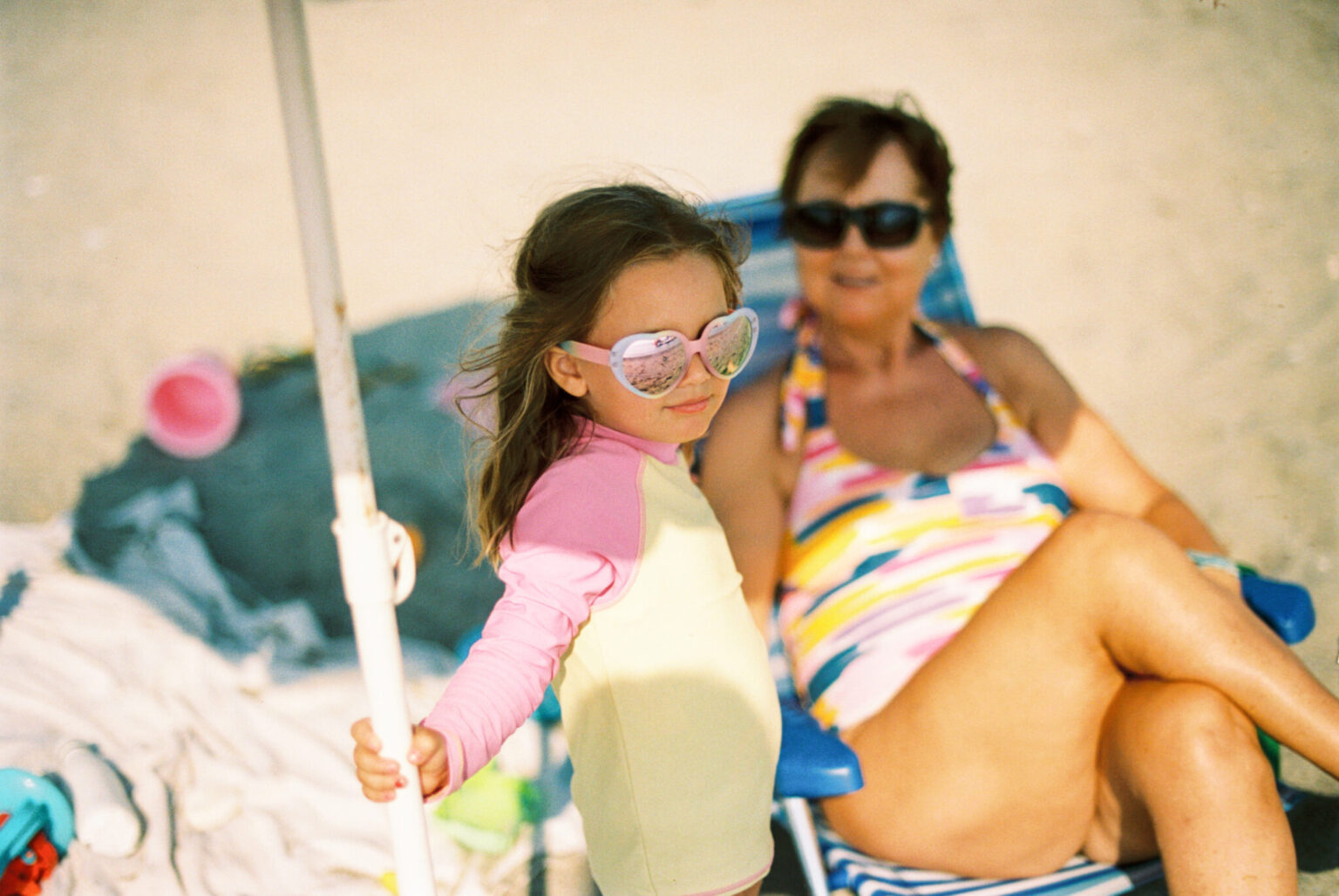 a woman and a girl in a bathing suit on a beach