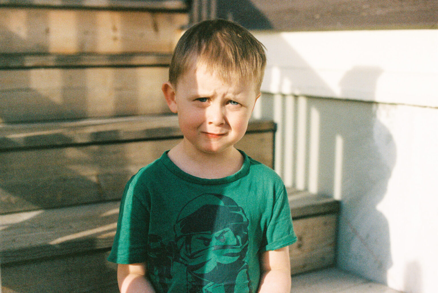 a boy standing outside on a porch