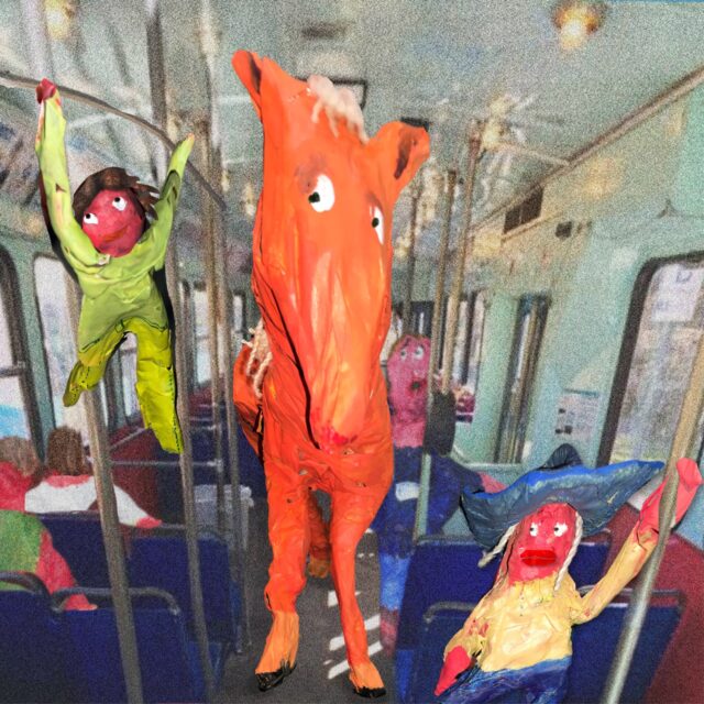 Paper mache figures of a person, horse, and character on a train.