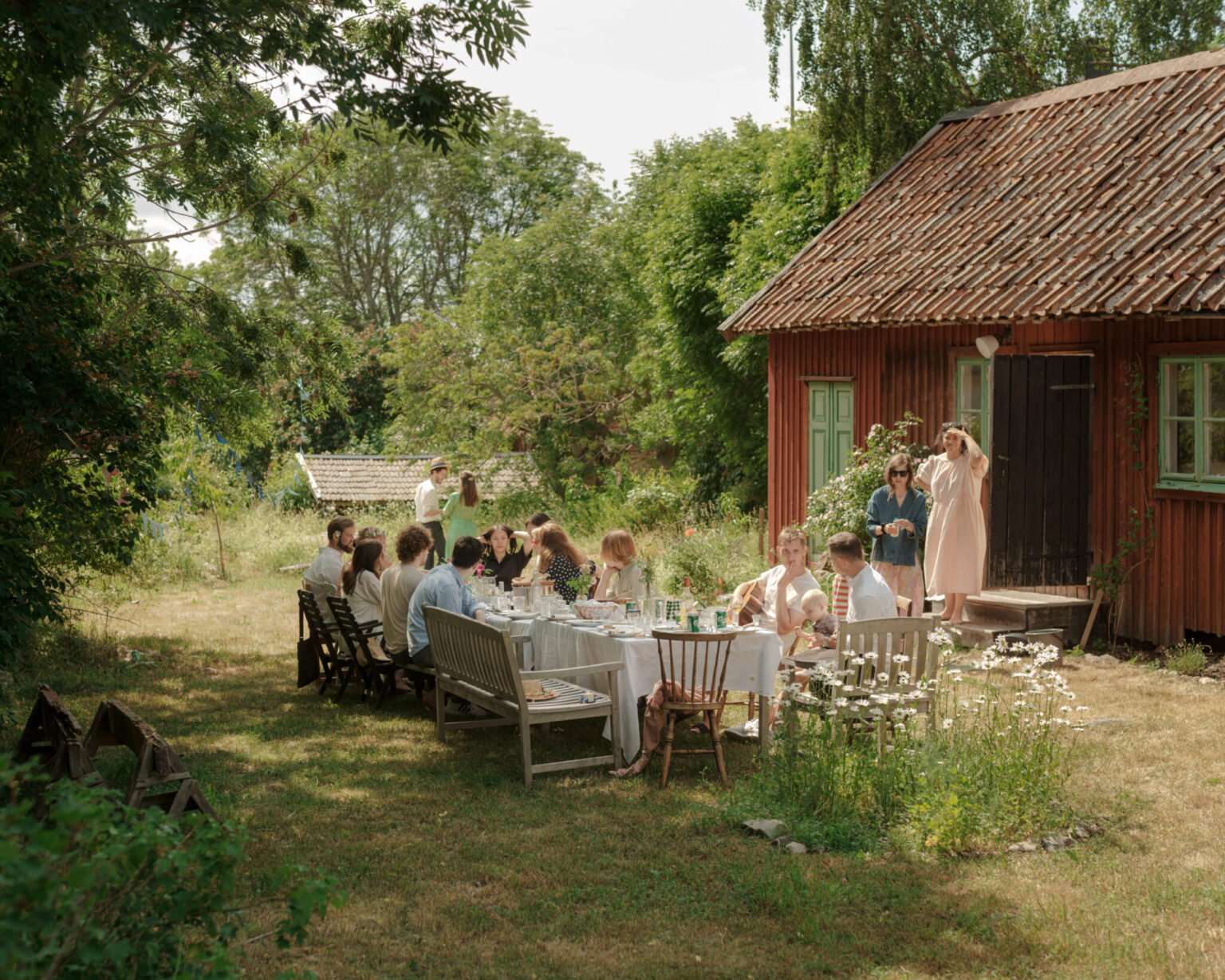 a group of people sitting around tables outside a house
