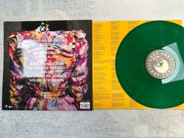 a green and yellow vinyl record with a picture of a person in a colorful jacket