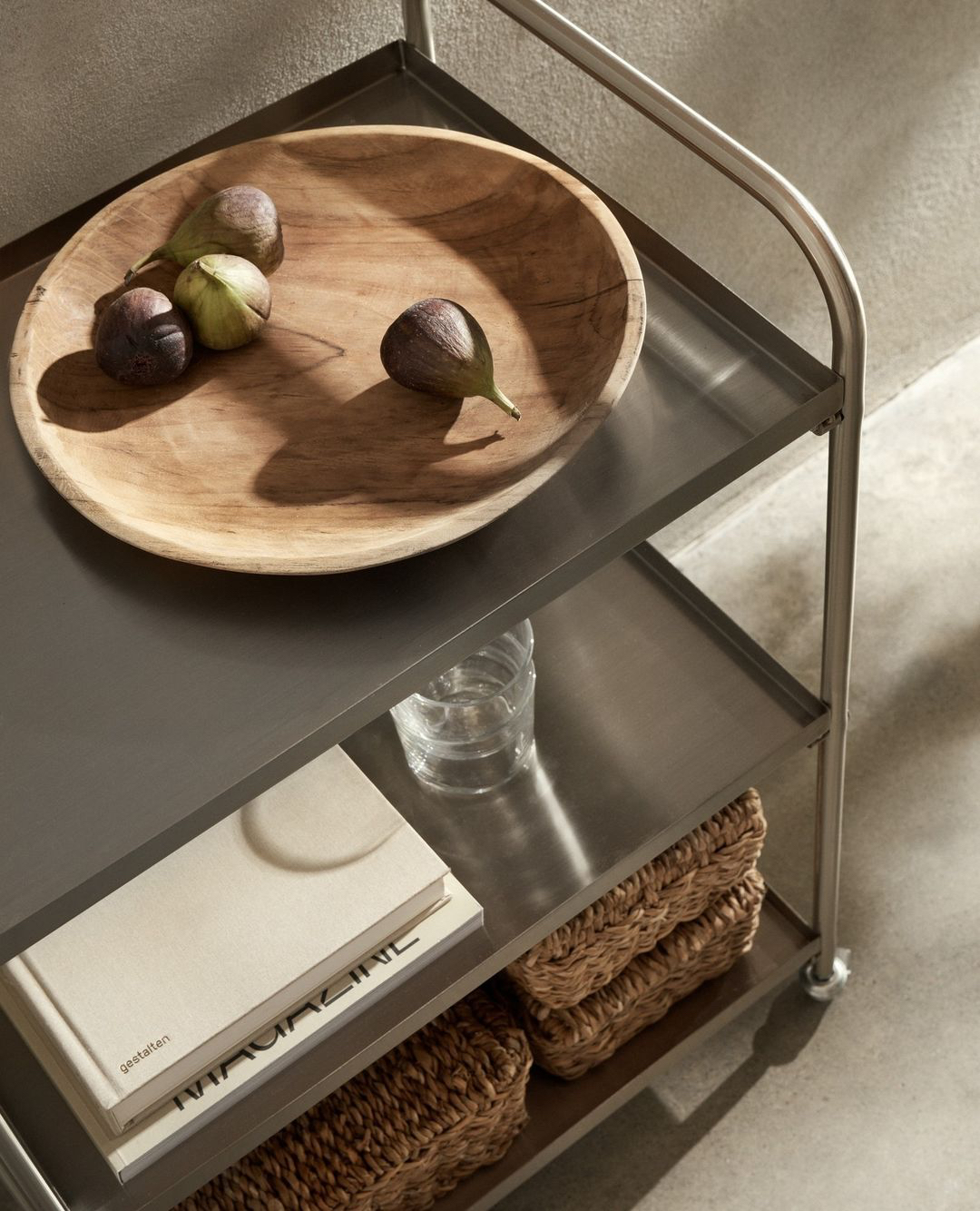 a wood bowl with figs on a metal shelf