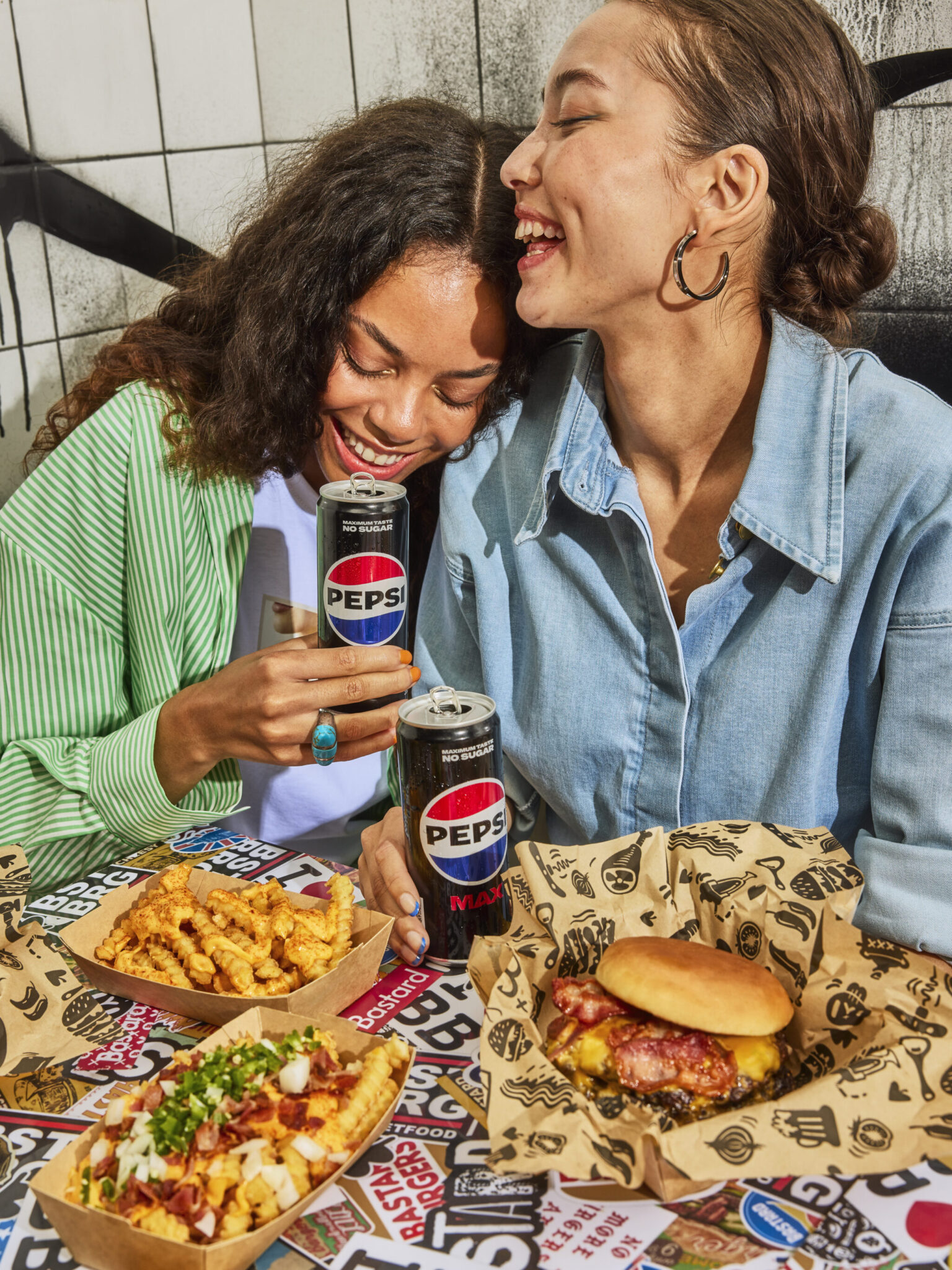 a couple of women sitting at a table with food