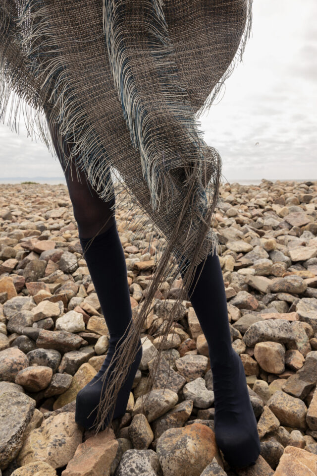 a person's legs in a skirt and black stockings