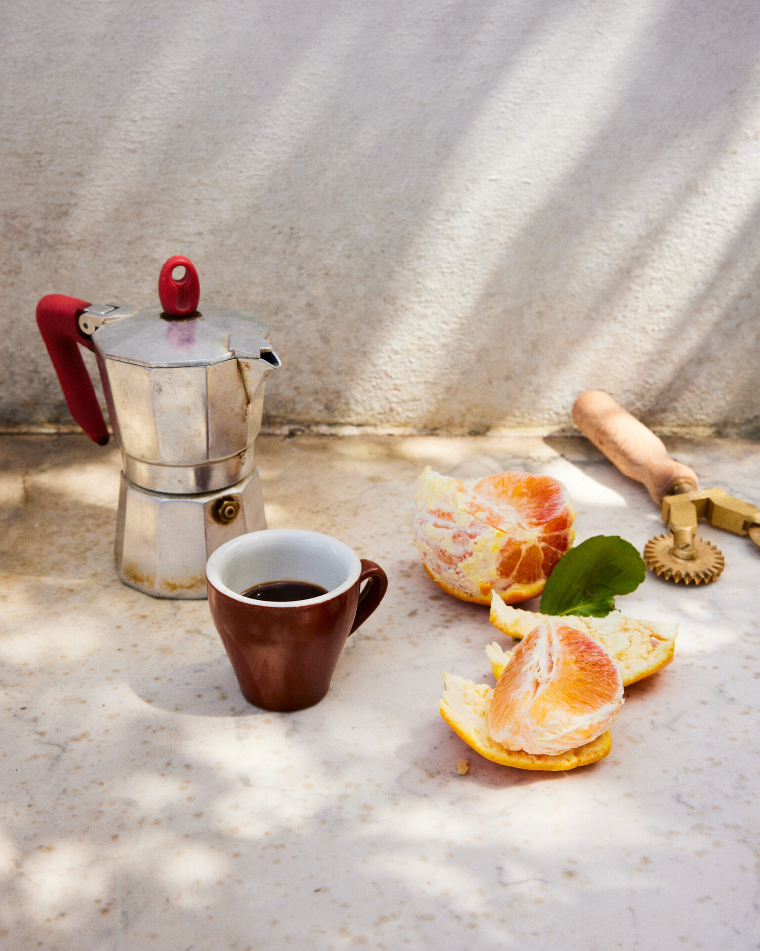 a coffee cup and oranges on a table