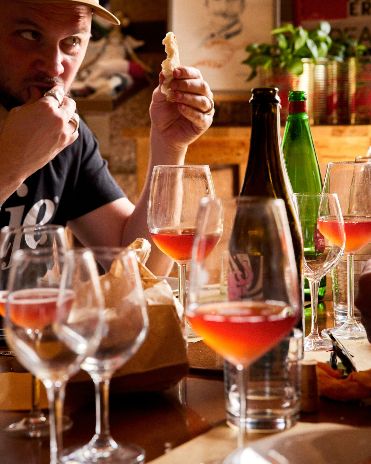 a man eating at a table with wine glasses and bottles