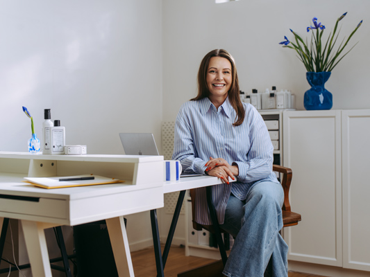 a woman sitting at a desk smiling