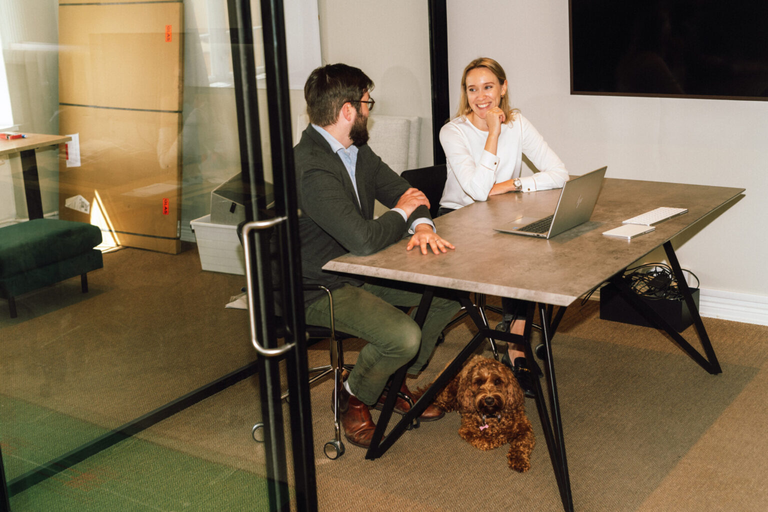 a man and woman sitting at a table with a dog