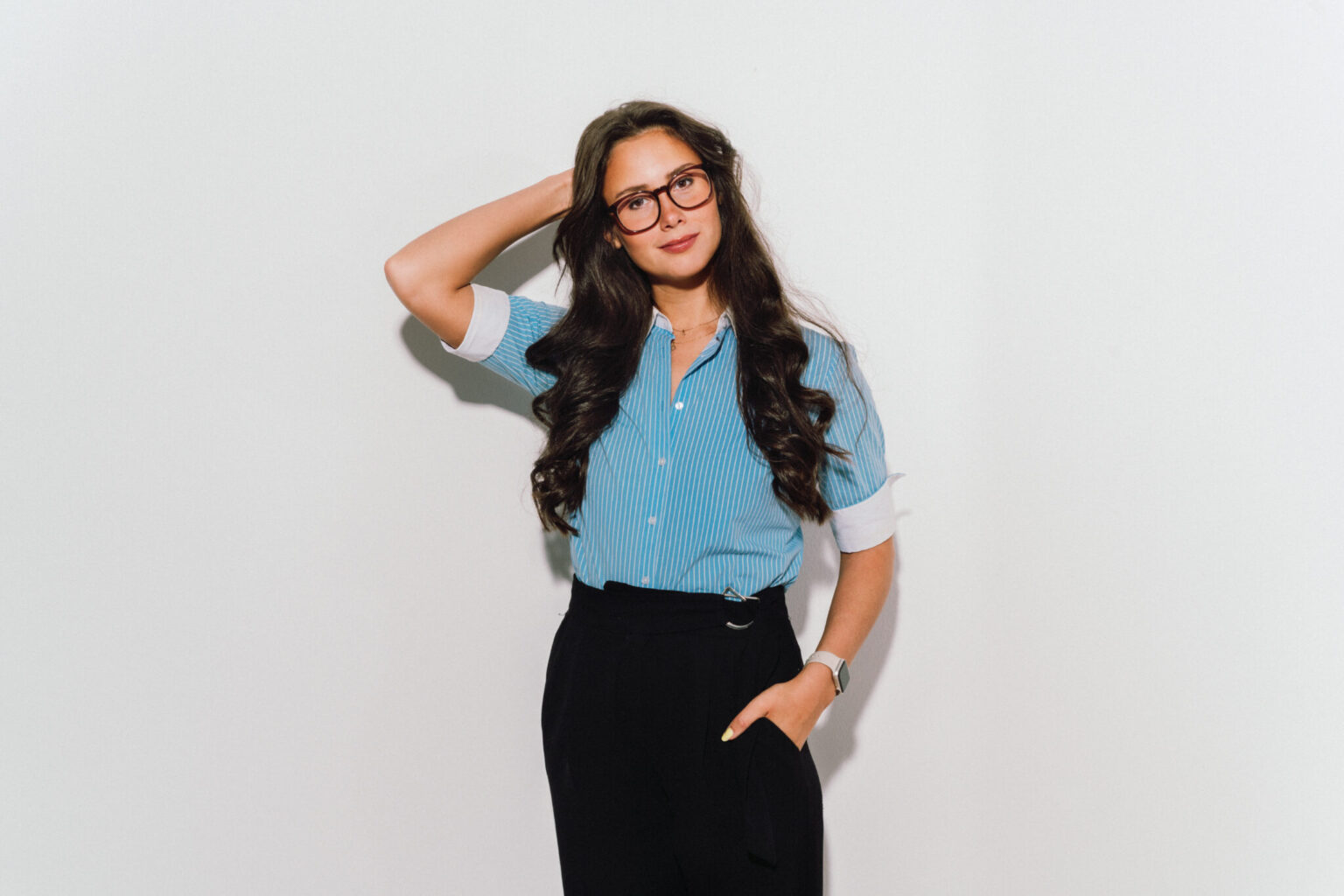 a woman with long hair wearing glasses and blue striped shirt