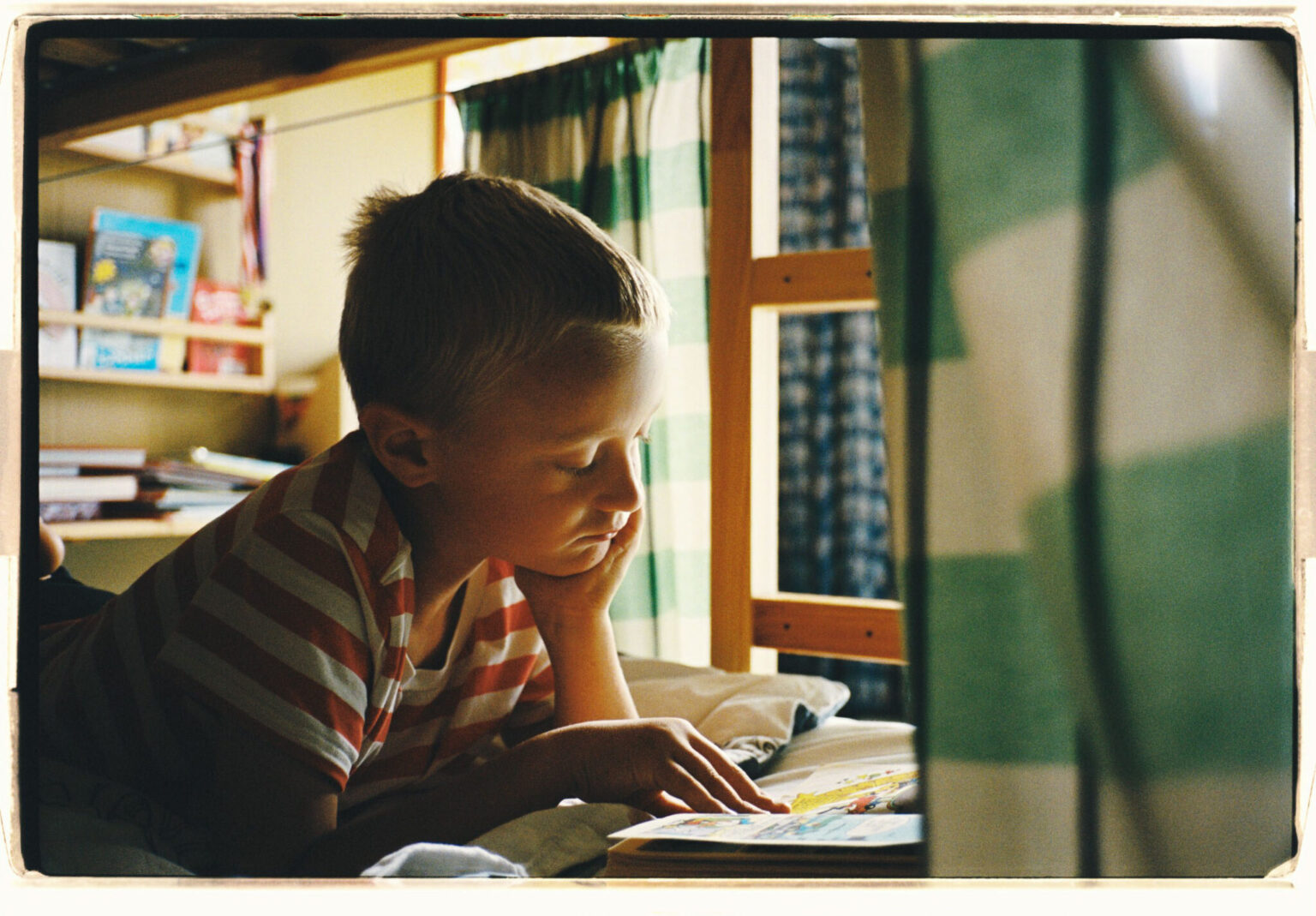 Barn som läser pocketbok i våningssäng.