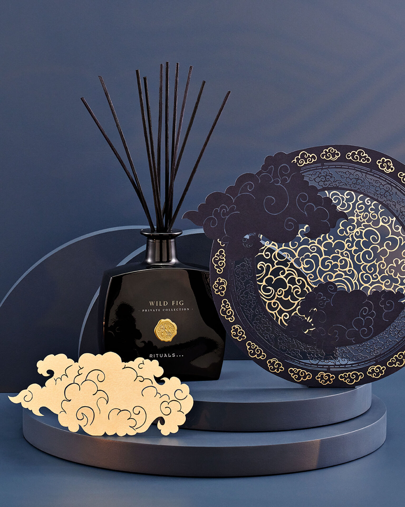 a black bottle with sticks next to a plate