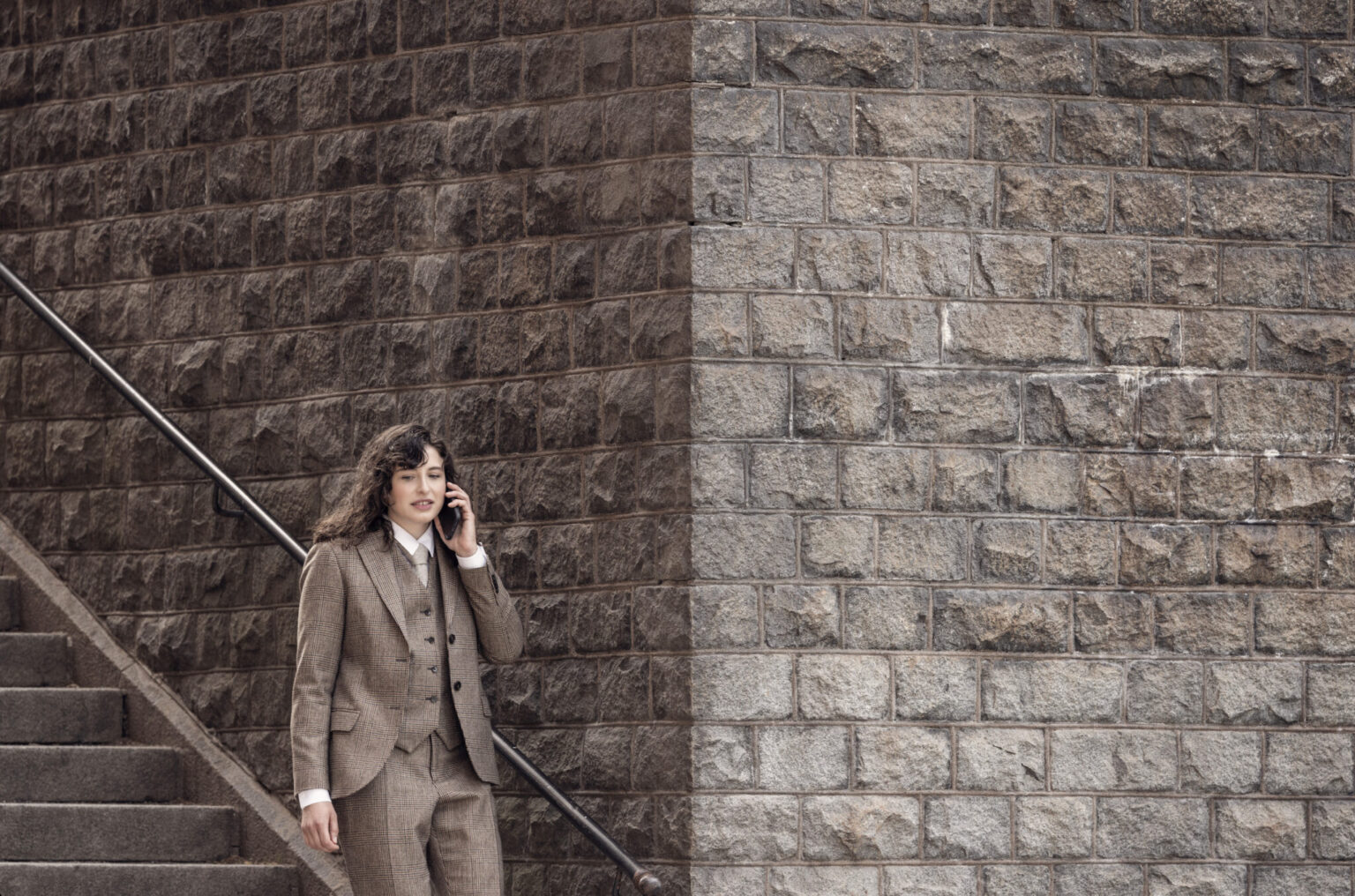 a woman in a suit talking on a cell phone