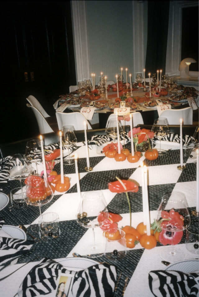 a table with black and white checkered tablecloths and candles